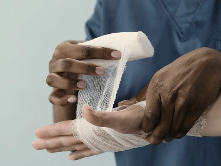 A clinician bandaging an injured hand